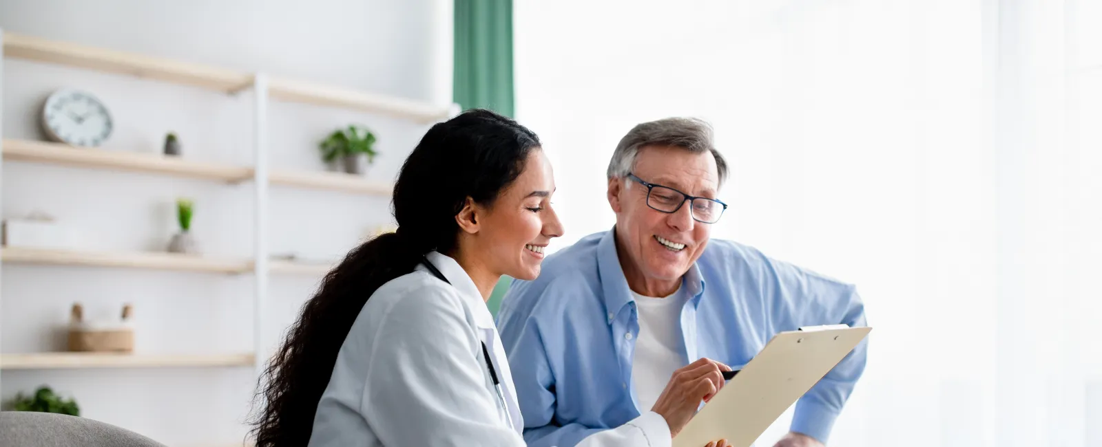 a man and a woman sitting on a couch and looking at a paper