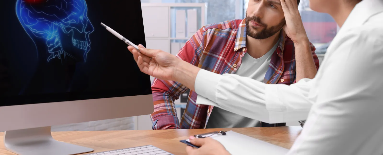 a man and a woman sitting at a table with a computer