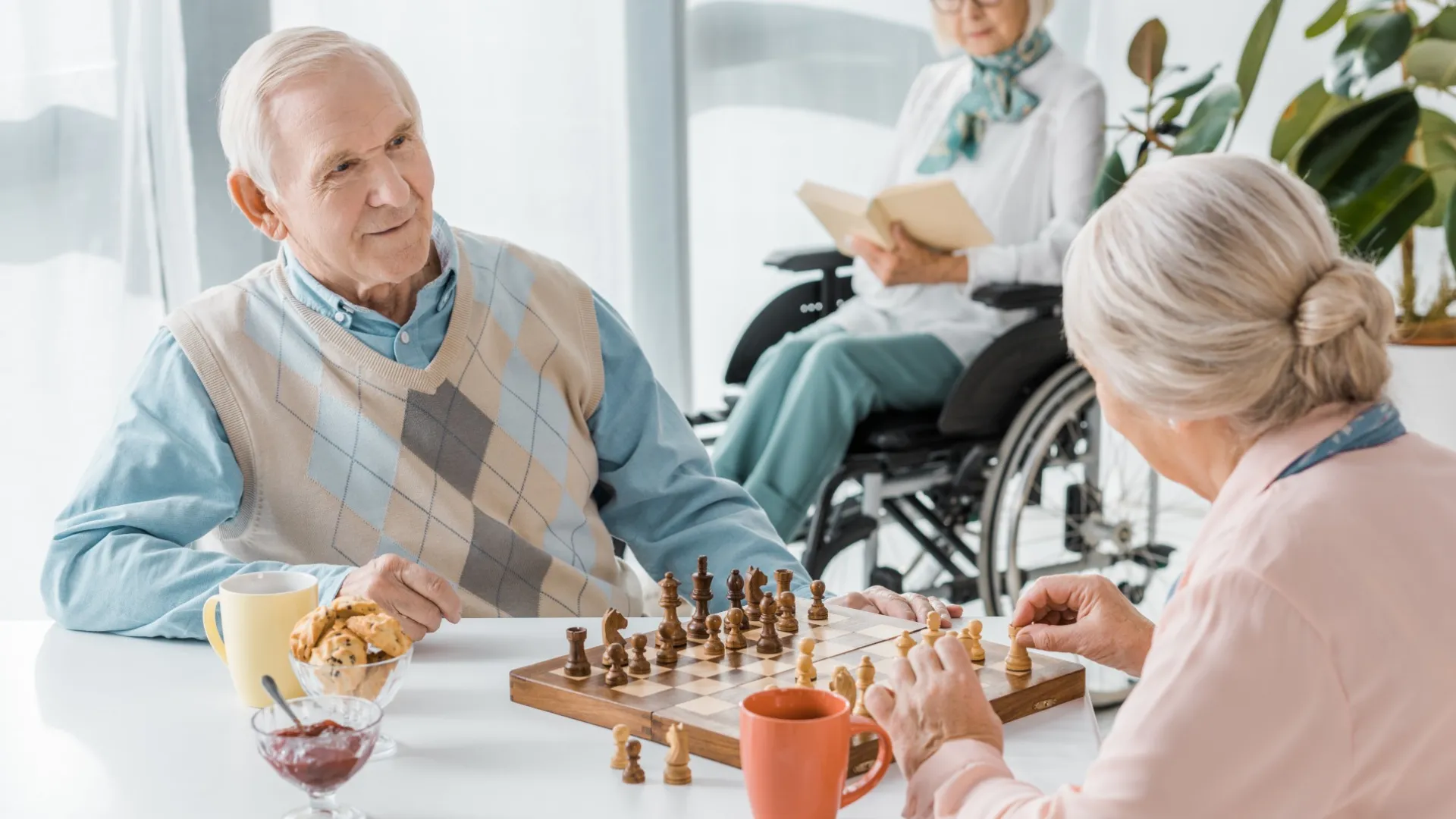 a group of people sitting around a table playing chess