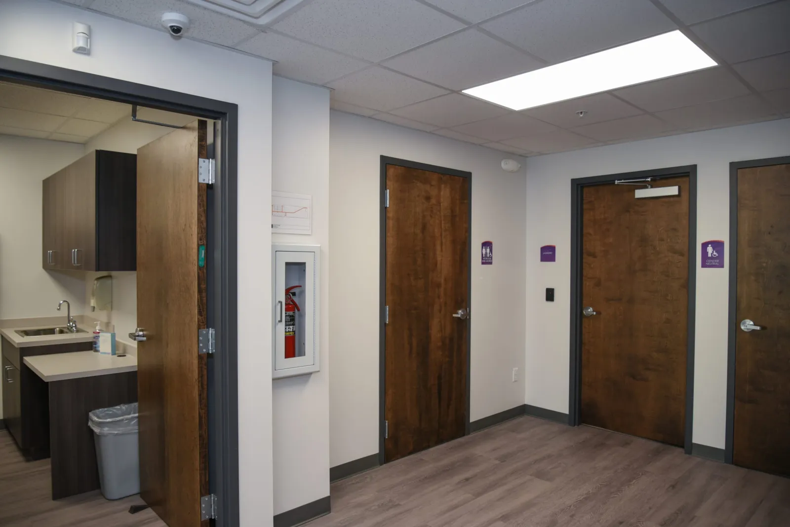 a room with a wood floor and brown doors