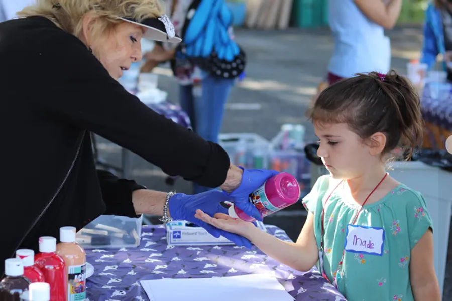 a person helping a child with a bottle