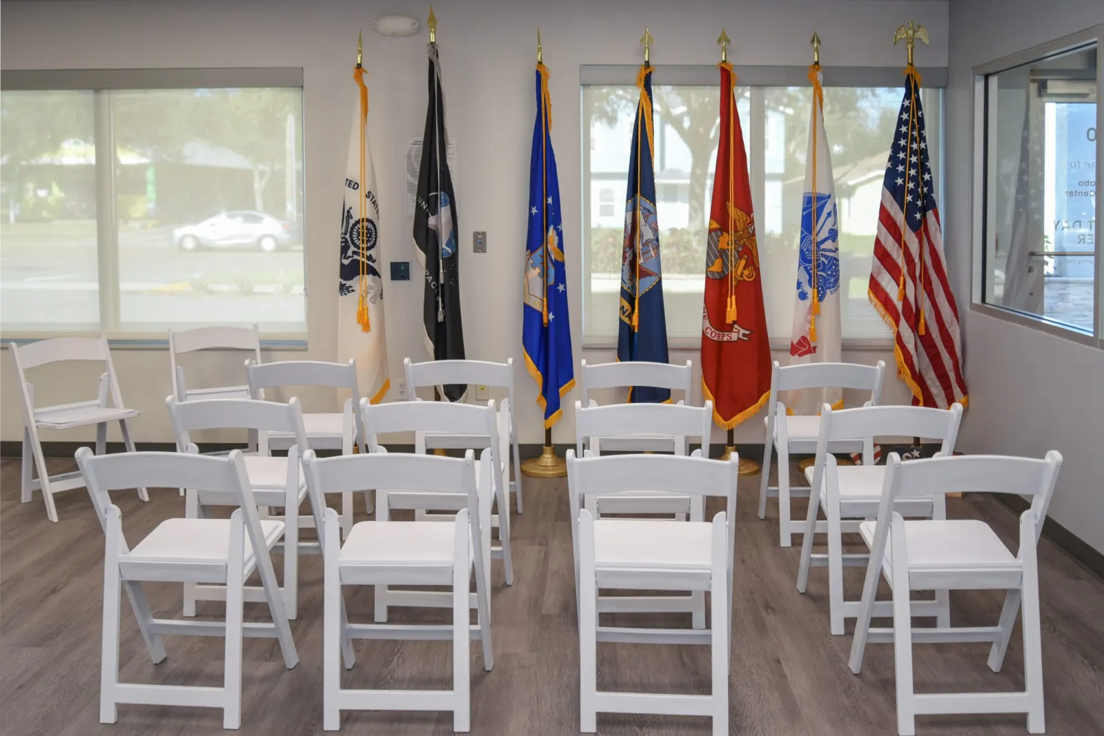 a room with white chairs and flags