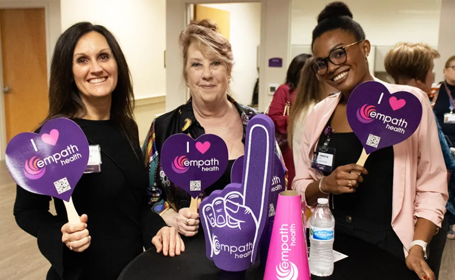 a group of women holding purple bags